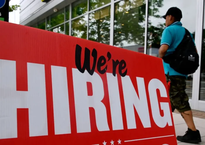 A man walks past a "now hiring" sign posted outside of a restaurant in Arlington, Virginia on June 3, 2022. US employers added 390,000 jobs last month, the government reported on June 3, 2022, a sign of a slowdown in hiring but still a better-than-expected result. The jobless rate held steady at 3.6 percent for the third consecutive month, just a tenth of a point above the pre-pandemic level of February 2020, the Labor Department said. (Photo by OLIVIER DOULIERY / AFP) (Photo by OLIVIER DOULIERY/AFP via Getty Images)