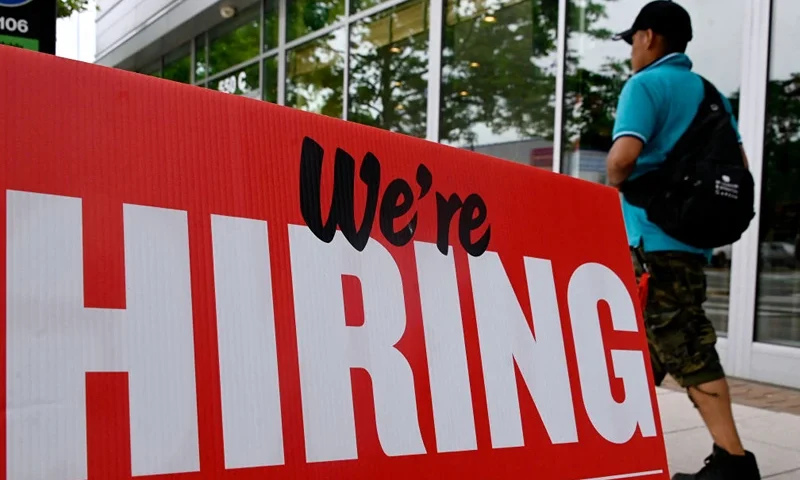 A man walks past a "now hiring" sign posted outside of a restaurant in Arlington, Virginia on June 3, 2022. US employers added 390,000 jobs last month, the government reported on June 3, 2022, a sign of a slowdown in hiring but still a better-than-expected result. The jobless rate held steady at 3.6 percent for the third consecutive month, just a tenth of a point above the pre-pandemic level of February 2020, the Labor Department said. (Photo by OLIVIER DOULIERY / AFP) (Photo by OLIVIER DOULIERY/AFP via Getty Images)