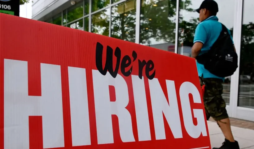 A man walks past a "now hiring" sign posted outside of a restaurant in Arlington, Virginia on June 3, 2022. US employers added 390,000 jobs last month, the government reported on June 3, 2022, a sign of a slowdown in hiring but still a better-than-expected result. The jobless rate held steady at 3.6 percent for the third consecutive month, just a tenth of a point above the pre-pandemic level of February 2020, the Labor Department said. (Photo by OLIVIER DOULIERY / AFP) (Photo by OLIVIER DOULIERY/AFP via Getty Images)