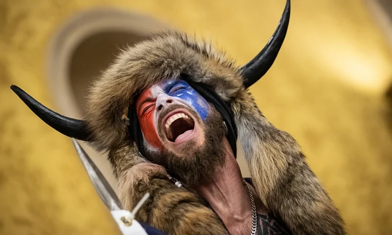 Trump Supporters Hold "Stop The Steal" Rally In DC Amid Ratification Of Presidential Election WASHINGTON, DC - JANUARY 06: Jacob Chansley, also known as the "QAnon Shaman," screams "Freedom" inside the U.S. Senate chamber after the U.S. Capitol was breached by a mob during a joint session of Congress on January 6, 2021 in Washington, DC. Congress held a joint session to ratify President-elect Joe Biden's 306-232 Electoral College win over President Donald Trump. Pro-Trump protesters illegally entered the U.S. Capitol building following rallies in the nation's capital. (Photo by Win McNamee/Getty Images)