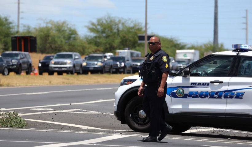 WAILUKU, HAWAII - AUGUST 11: A Maui police officer monitors traffic on the Honoapiilani highway as cars back up for miles before residents are allowed back into areas affected by the recent wildfire on August 11, 2023 in Wailuku, Hawaii. Dozens of people were killed and thousands were displaced after a wind-driven wildfire devastated the town of Lahaina on Tuesday. Crews are continuing to search for missing people. (Photo by Justin Sullivan/Getty Images)