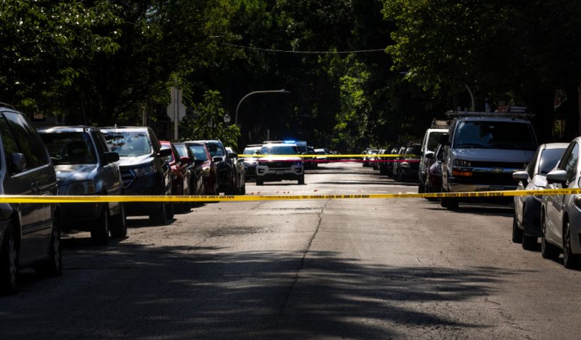 CHICAGO, ILLINOIS - JULY 06: Police investigate the scene of a drive-by shooting on July 06, 2024 in Chicago, Illinois. At least 103 people were shot, 19 fatally, in gun violence in the city over the long Fourth of July holiday weekend. (Photo by Scott Olson/Getty Images)
