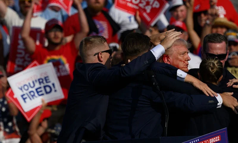 BUTLER, PENNSYLVANIA - JULY 13: Republican presidential candidate, former U.S. President Donald Trump is whisked away by Secret Service after shots rang out at a campaign rally at Butler Farm Show Inc. on July 13, 2024 in Butler, Pennsylvania. Trump slumped and injuries were visible to the side of his head. Butler County district attorney Richard Goldinger said the shooter and one audience member are dead and another was injured. (Photo by Jeff Swensen/Getty Images)