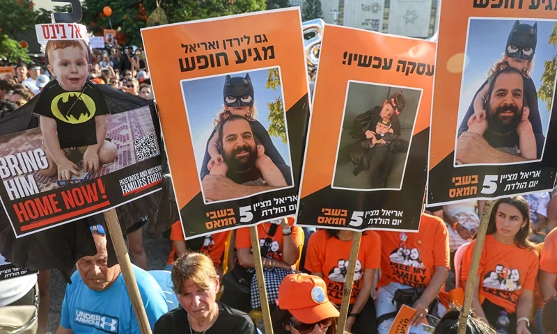Participants lift placards and pictures during a gathering in Tel Aviv on August 5, 2024 to mark the fifth birthday of Ariel Bibas, held hostage in Gaza, and to call for the liberation of him and his family. Ariel, his baby brother Kfir, who would now be one year old, were kidnapped along with their parents Yarden and Shiri from their homes in Nir Oz kibbutz community near Gaza on October 7 when Hamas militants attacked southern Israel. (Photo by GIL COHEN-MAGEN / AFP) (Photo by GIL COHEN-MAGEN/AFP via Getty Images)