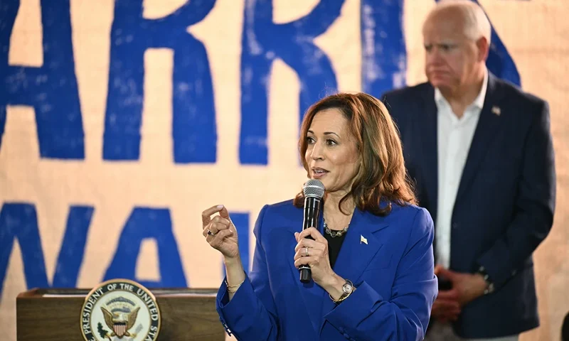 US Vice President and Democratic presidential candidate Kamala Harris speaks as her running mate Minnesota Governor Tim Walz looks on during a stop on their campaign bus tour in Rochester, Pennsylvania, on August 18, 2024. Harris embarked on a bus tour of the potentially election-deciding state of Pennsylvania on Sunday, as she keeps up the momentum before her star turn at the Democratic National Convention in Chicago. (Photo by ANGELA WEISS / AFP) (Photo by ANGELA WEISS/AFP via Getty Images)