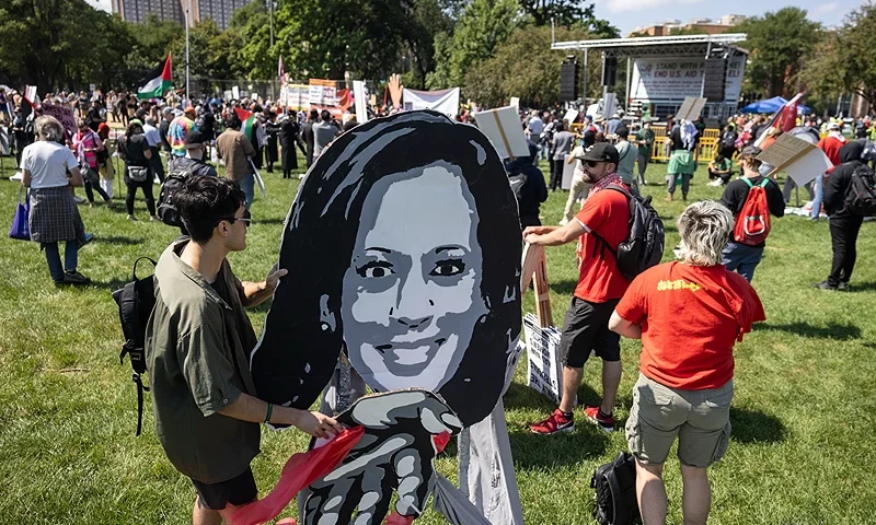 A protestor holds an image of US Vice President and 2024 Democratic presidential candidate Kamala Harris as pro-Palestinian protesters in Union Park prepare to march before the start of the Democratic National Convention (DNC) in Chicago, Illinois, on August 19, 2024. (Photo by CHRISTIAN MONTERROSA / AFP) (Photo by CHRISTIAN MONTERROSA/AFP via Getty Images)