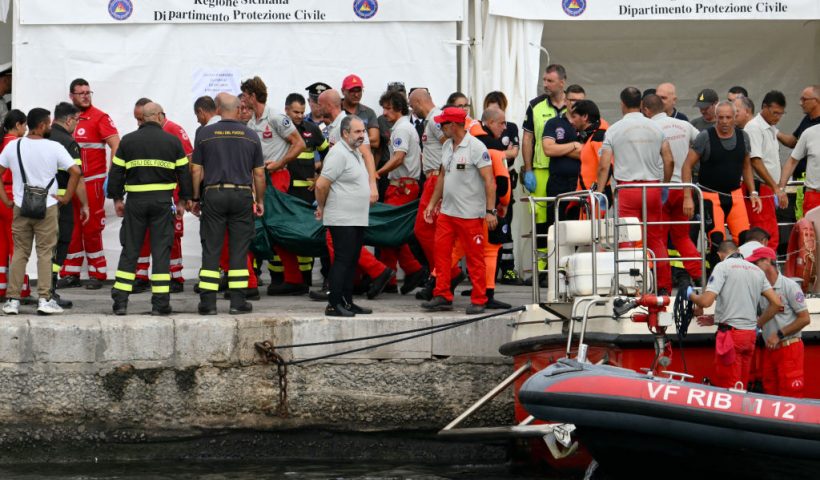 Rescuers carry a body bag in Porticello near Palermo, on August 21, 2024 two days after the British-flagged luxury yacht Bayesian sank. Divers searching for six missing people following the sinking of a superyacht off Sicily in a storm have found two bodies, a source close to the search told AFP. The Bayesian, which had 22 people aboard including 10 crew, was anchored some 700 metres from port before dawn when it was struck by a waterspout, a sort of mini tornado. Fifteen people aboard, including a mother with a one-year-old baby, were plucked to safety; one man has been found dead; and six people remain missing. (Photo by Alberto PIZZOLI / AFP) (Photo by ALBERTO PIZZOLI/AFP via Getty Images)