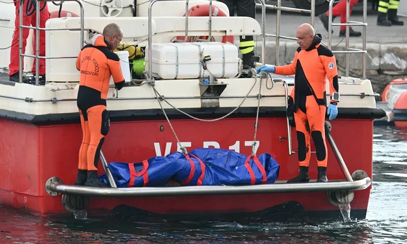 Divers of the Vigili del Fuoco, the Italian Corps. of Firefighters arrive in Porticello harbor near Palermo, with the body of Mike Lynch at the back of the boat on August 22, 2024, three days after the British-flagged luxury yacht Bayesian sank. Divers searching for six missing people following the sinking of a superyacht off Sicily in a storm have found fifth bodies. The Bayesian, which had 22 people aboard including 10 crew, was anchored some 700 metres from port before dawn when it was struck by a waterspout. Among the six missing were UK tech entrepreneur Mike Lynch and his 18-year-old daughter Hannah, and Jonathan Bloomer, the chair of Morgan Stanley International, and his wife Judy. (Photo by Alberto PIZZOLI / AFP) (Photo by ALBERTO PIZZOLI/AFP via Getty Images)