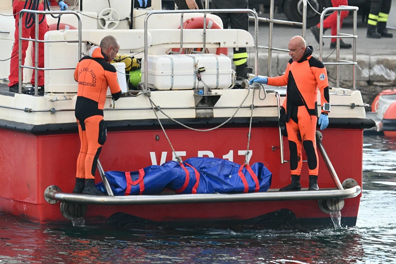 Divers of the Vigili del Fuoco, the Italian Corps. of Firefighters arrive in Porticello harbor near Palermo, with the body of Mike Lynch at the back of the boat on August 22, 2024, three days after the British-flagged luxury yacht Bayesian sank. Divers searching for six missing people following the sinking of a superyacht off Sicily in a storm have found fifth bodies. The Bayesian, which had 22 people aboard including 10 crew, was anchored some 700 metres from port before dawn when it was struck by a waterspout. Among the six missing were UK tech entrepreneur Mike Lynch and his 18-year-old daughter Hannah, and Jonathan Bloomer, the chair of Morgan Stanley International, and his wife Judy. (Photo by Alberto PIZZOLI / AFP) (Photo by ALBERTO PIZZOLI/AFP via Getty Images)