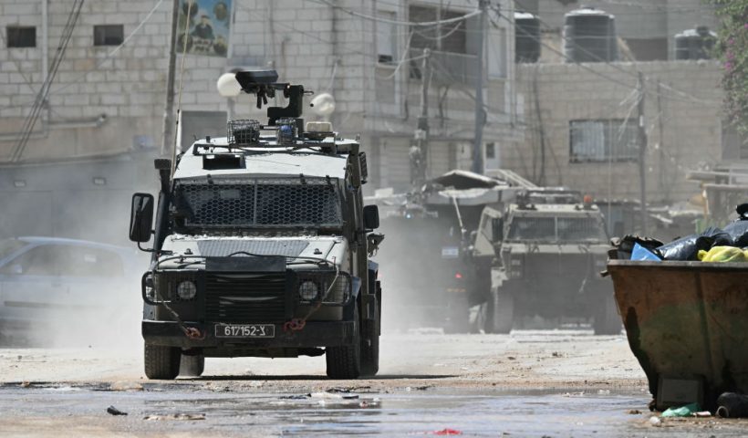 An Israeli military vehicle drives down a road during a raid in Jenin in the occupied West Bank on August 28, 2024. At least 10 Palestinians were killed in Israeli raids and strikes in several towns in the north of the occupied West Bank, a spokesman for the Red Crescent said on August 28. The operation comes two days after Israel said it carried out an air strike on the West Bank that the Palestinian Authority reported killed five people. (Photo by RONALDO SCHEMIDT / AFP) (Photo by RONALDO SCHEMIDT/AFP via Getty Images)