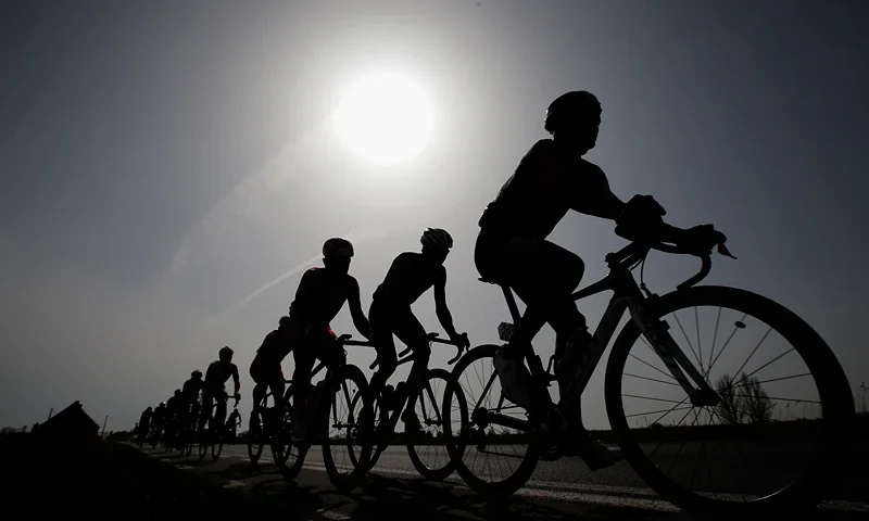 Gent-Wevelgem Cycle Race GENT, BELGIUM - MARCH 30: A general view of the peloton silhouetted against the sun during the Gent-Wevelgem Cycle Race on March 30, 2014 in Gent, Belgium. (Photo by Dean Mouhtaropoulos - Velo/Getty Images)