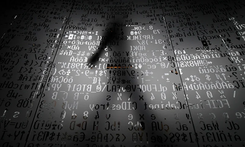 TOPSHOT - A picture taken on October 17, 2016 shows an employee walking behind a glass wall with machine coding symbols at the headquarters of Internet security giant Kaspersky in Moscow. / AFP / Kirill KUDRYAVTSEV / TO GO WITH AFP STORY BY Thibault MARCHAND (Photo credit should read KIRILL KUDRYAVTSEV/AFP via Getty Images)