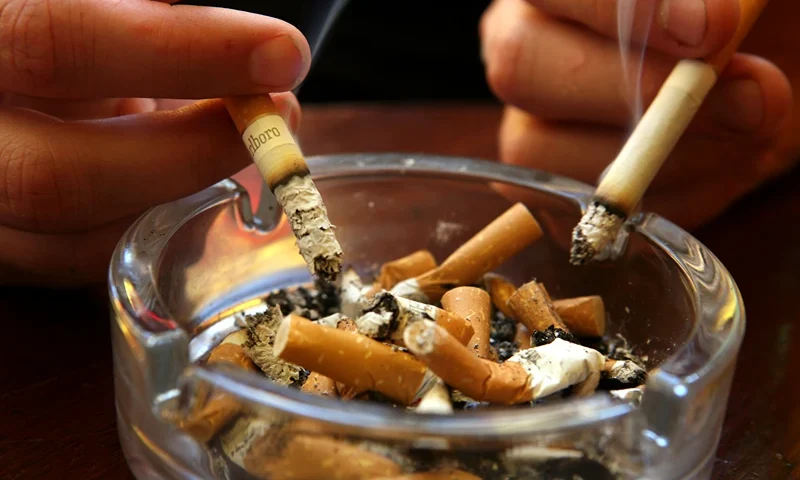 A couple smoke cigarettes in a public house in Bath, on June 30 2007 in Somerset, England. From 6am July 1 smoking in all enclosed places such as cafes and pubs will be banned. (Photo by Matt Cardy/Getty Images)
