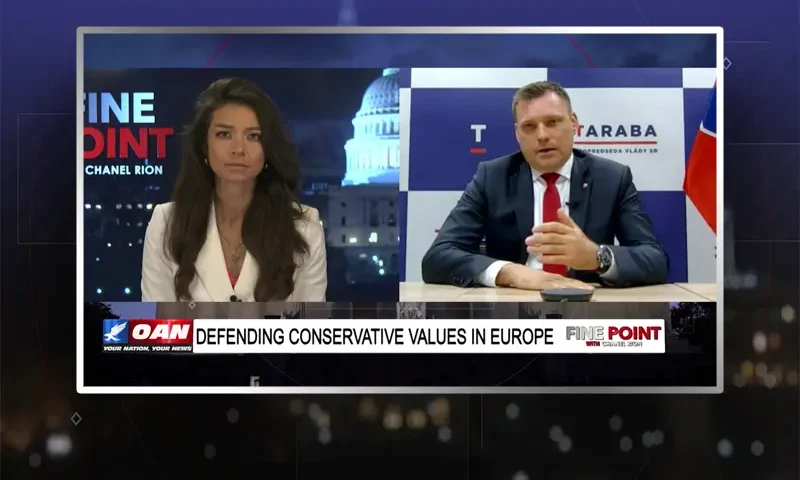 Video still from Fine Point on One America News Network showing a split screen of the host on the left side, and on the right side is the guest, Tomáš Taraba.