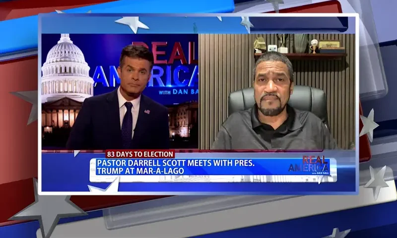 Video still from Real America on One America News Network showing a split screen of the host on the left side, and on the right side is the guest, Darrell Scott.