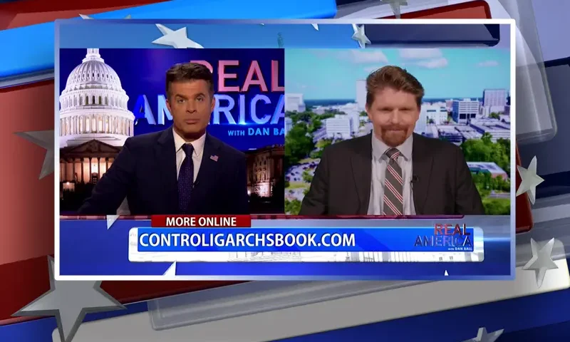 Video still from Real America on One America News Network showing a split screen of the host on the left side, and on the right side is the guest, Seamus Bruner.
