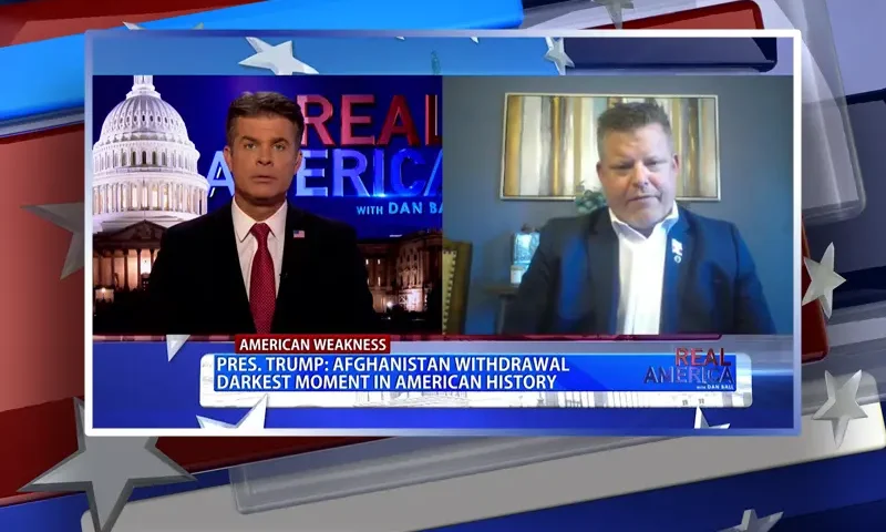 Video still from Real America on One America News Network showing a split screen of the host on the left side, and on the right side is the guest, Jared Schmitz.