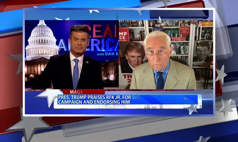 Video still from Real America on One America News Network showing a split screen of the host on the left side, and on the right side is the guest, Roger Stone.