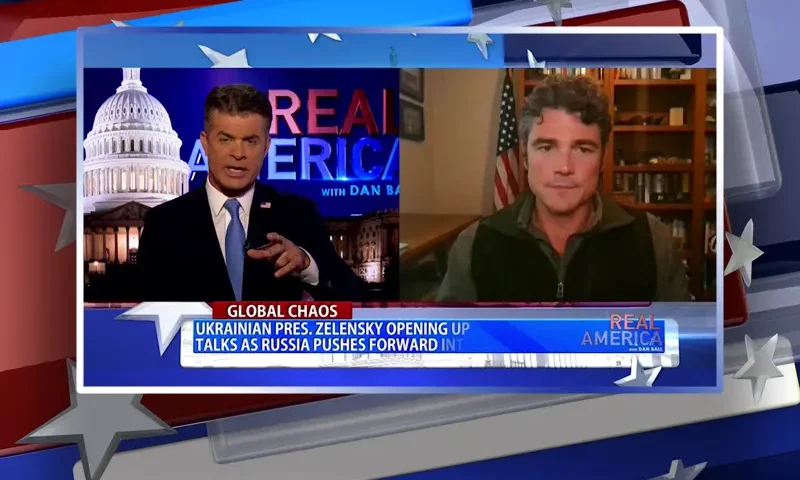 Video still from Real America on One America News Network showing a split screen of the host on the left side, and on the right side is the guest, Joe Kent.