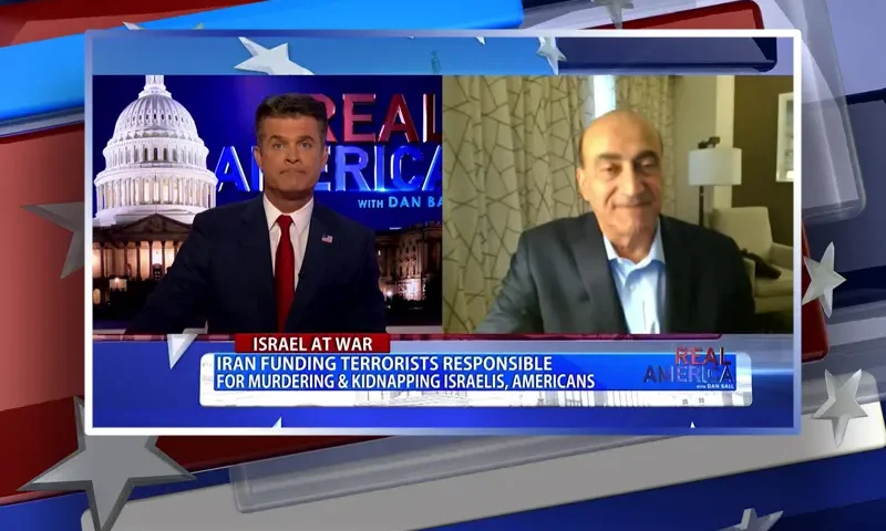 Video still from Real America on One America News Network showing a split screen of the host on the left side, and on the right side is the guest, Dr. Walid Phares.