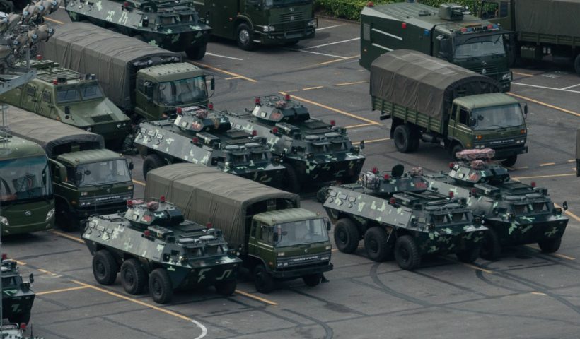 TOPSHOT - Trucks and armoured personnel carriers are seen parked at the Shenzhen Bay stadium in Shenzhen, bordering Hong Kong in China's southern Guangdong province, on August 16, 2019. - Chinese military personnel and armoured personnel carriers have mustered in large numbers across the border in Shenzhen, as Hong Kong's pro-democracy movement faces a major test this weekend as it tries to muster another huge crowd following criticism over a recent violent airport protest and as Beijing ramps up its bellicose threats. (Photo by STR / AFP) (Photo credit should read STR/AFP via Getty Images)