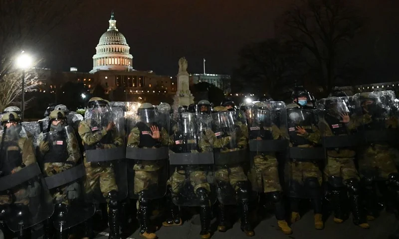 National Guard troops clear a street from protestors outside the Capitol building on January 6, 2021 in Washington, DC. - Donald Trump's supporters stormed a session of Congress held today, January 6, to certify Joe Biden's election win, triggering unprecedented chaos and violence at the heart of American democracy and accusations the president was attempting a coup. (Photo by ROBERTO SCHMIDT / AFP) (Photo by ROBERTO SCHMIDT/AFP via Getty Images)