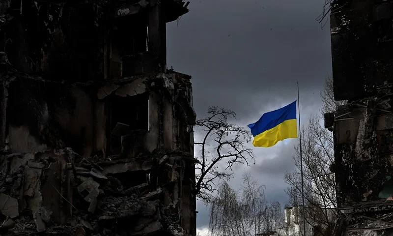 TOPSHOT - The Ukrainian flag flutters between buildings destroyed in bombardment, in the Ukrainian town of Borodianka, in the Kyiv region on April 17, 2022. - Russia invaded Ukraine on February 24, 2022. (Photo by Sergei SUPINSKY / AFP) (Photo by SERGEI SUPINSKY/AFP via Getty Images)