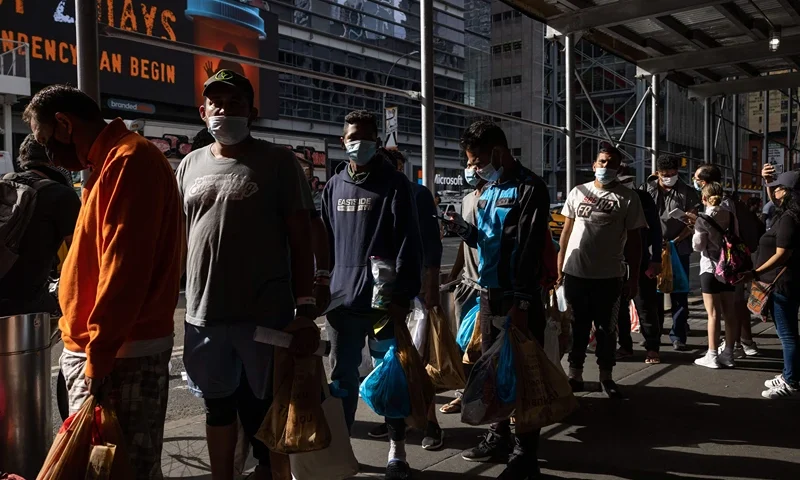 A group of migrants wait in line after arriving from Texas, outside Port Authority Bus Terminal to receive humanitarian assistance on August 10, 2022 in New York. - Texas has sent thousands of migrants from the border state into Washington, DC, New York City, and other areas. (Photo by Yuki IWAMURA / AFP) (Photo by YUKI IWAMURA/AFP via Getty Images)