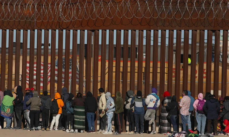 Migrants queue at the border wall to be received by Border Patrol agents after crossing the Rio Bravo river (or Rio Grande river, as it is called in the US) from Ciudad Juarez, Chihuahua state, Mexico to El Paso, Texas, US on December 21, 2022. - Title 42, a President Donald Trump pandemic-era law that authorize United States border officials to expel migrants, is supposed to end on December 21. (Photo by Herika Martinez / AFP) (Photo by HERIKA MARTINEZ/AFP via Getty Images)