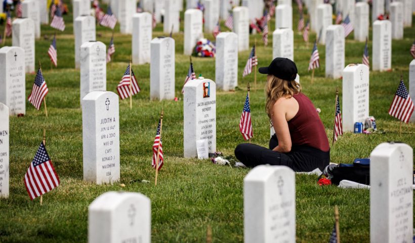 ARLINGTON, VIRGINIA - MAY 29: Krista Meinert sits with her son, US Marine Corps Lance Corporal Jacob Meinert who was killed in Afghanistan, at Arlington National Cemetery on Memorial Day, May 29, 2023 in Arlington, Virginia. The U.S. celebrates Memorial Day each year to honor those who have died while serving in the armed forces. (Photo by Samuel Corum/Getty Images)