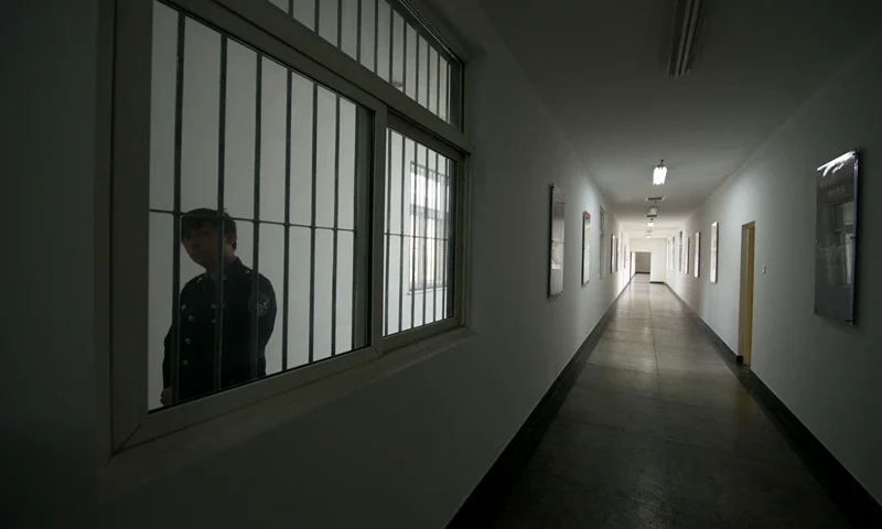 A guard looks through the window of a hallway inside the No.1 Detention Center during a government guided tour in Beijing on October 25, 2012. The rare visit to the facility, which has capacity for 1,000 inmates, was opened to the foreign media as Beijing prepares for the 18th Congress of the Communist Party of China. AFP PHOTO / Ed Jones (Photo by Ed Jones / AFP) (Photo by ED JONES/AFP via Getty Images)