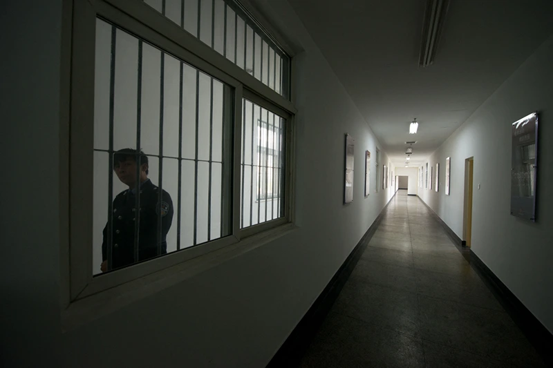 A guard looks through the window of a hallway inside the No.1 Detention Center during a government guided tour in Beijing on October 25, 2012. The rare visit to the facility, which has capacity for 1,000 inmates, was opened to the foreign media as Beijing prepares for the 18th Congress of the Communist Party of China. AFP PHOTO / Ed Jones (Photo by Ed Jones / AFP) (Photo by ED JONES/AFP via Getty Images)