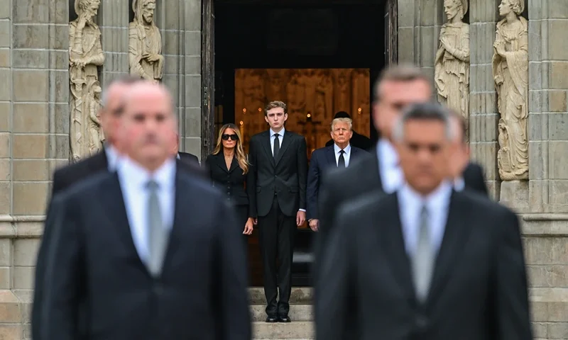 TOPSHOT - Former US President Donald Trump (center right) stands with his wife Melania Trump (center left) their son Barron Trump (center) and father-in-law Viktor Knavs (out of frame), as the coffin carrying the remains of Amalija Knavs, the former first lady's mother, is carried into the Church of Bethesda-by-the-Sea for her funeral, in Palm Beach, Florida, on January 18, 2024. Former first lady Melania Trump's mother Amalija Knavs, 78, died January 9, 2024 in Miami following an undisclosed illness. (Photo by GIORGIO VIERA / AFP) (Photo by GIORGIO VIERA/AFP via Getty Images)