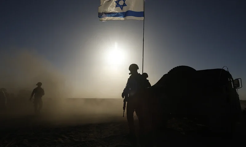 SOUTHERN ISRAEL - MARCH 4: Soldiers with the Israel Defense Forces stand near a military vehicle on March 4, 2024 in southern Israel near the border with Gaza. Over the weekend, the U.S. vice president voiced the most forceful demand yet that there be an immediate ceasefire in the conflict, imploring Hamas to agree to the a six-week pause in fighting and calling on Israel to increase the flow of aid into the territory. (Photo by Amir Levy/Getty Images)