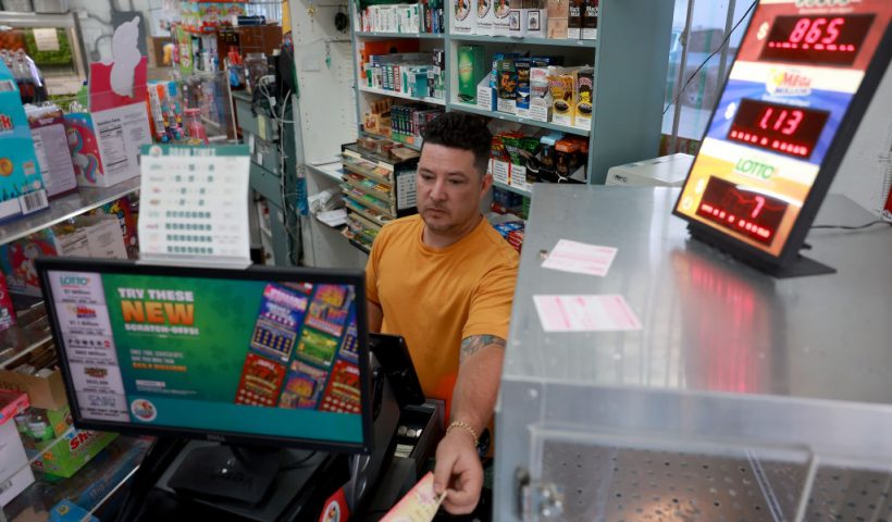 MIAMI, FLORIDA - MARCH 26: Karl Lopez prints out a Mega Million lottery ticket for a customer at the La Esquina Tropical supermarket on March 26, 2024 in Miami, Florida. The Mega Millions jackpot has reached $1.13 billion for tonight's drawing. (Photo Joe Raedle/Getty Images)
