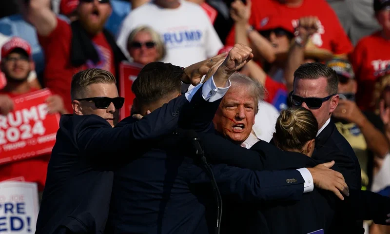 BUTLER, PENNSYLVANIA - JULY 13: Republican presidential candidate, former U.S. President Donald Trump is whisked away by Secret Service after shots rang out at a campaign rally at Butler Farm Show Inc. on July 13, 2024 in Butler, Pennsylvania. Trump slumped and injuries were visible to the side of his head. Butler County district attorney Richard Goldinger said the shooter and one audience member are dead and another was injured. (Photo by Jeff Swensen/Getty Images)