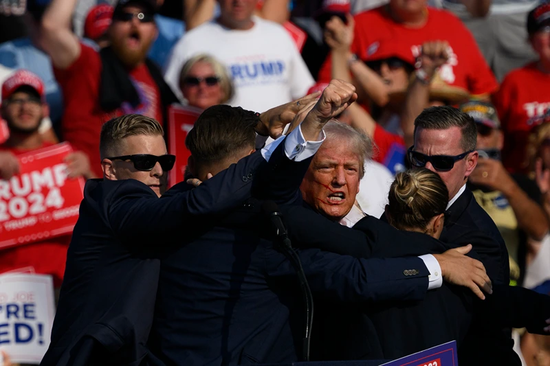 BUTLER, PENNSYLVANIA - JULY 13: Republican presidential candidate, former U.S. President Donald Trump is whisked away by Secret Service after shots rang out at a campaign rally at Butler Farm Show Inc. on July 13, 2024 in Butler, Pennsylvania. Trump slumped and injuries were visible to the side of his head. Butler County district attorney Richard Goldinger said the shooter and one audience member are dead and another was injured. (Photo by Jeff Swensen/Getty Images)