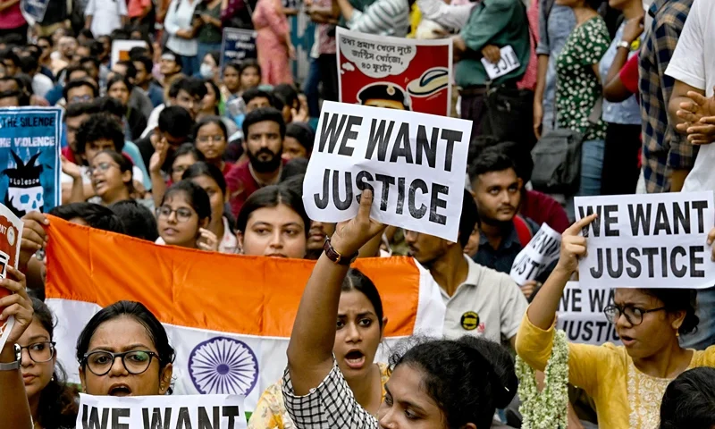 Junior doctors carry India's national flag and hold placards during a protest to demand the resignation of a city police commissioner and condemn the rape and murder of a medic, in Kolkata on September 2, 2024. The discovery of the 31-year-old doctor's bloodied body at a state-run hospital in Kolkata on August 9 stoked nationwide anger at the chronic issue of violence against women, that sparked strikes by medics and rallies backed by thousands of ordinary citizens across India. (Photo by Dibyangshu SARKAR / AFP) (Photo by DIBYANGSHU SARKAR/AFP via Getty Images)