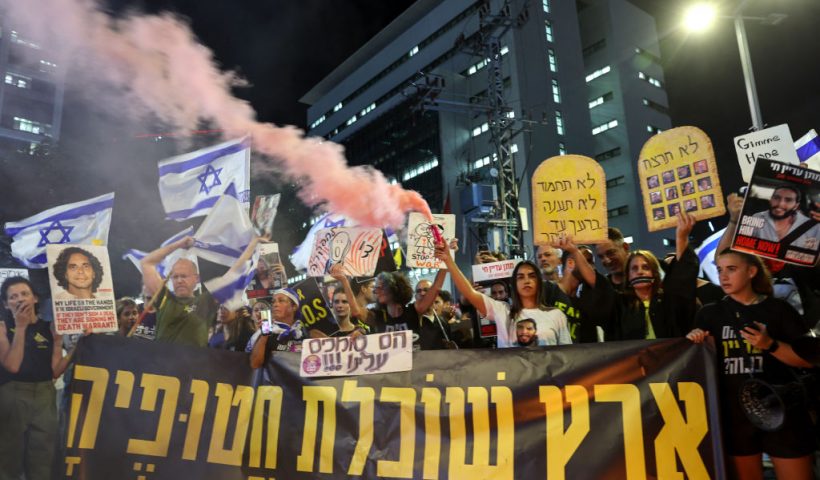 Demonstrators chant slogans and wave national flags during an anti-government protest calling for action to secure the release of Israeli hostages held captive since the October 7 attacks by Palestinian militants in the Gaza Strip, in front of the Israeli Defence Ministry in the coastal city of Tel Aviv on September 3, 2024, amid the ongoing war between Israel and the militant Hamas group. (Photo by Jack GUEZ / AFP) (Photo by JACK GUEZ/AFP via Getty Images)