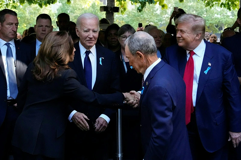 US Vice President and Democratic presidential candidate Kamala Harris (L) shakes hands with former US President and Republican presidential candidate Donald Trump (R) as former Mayor of New York Michael Bloomberg (C) and US President Joe Biden (2L) look on during a remembrance ceremony on the 23rd anniversary of the September 11 terror attack on the World Trade Center at Ground Zero, in New York City on September 11, 2024. (Photo by Adam GRAY / AFP) (Photo by ADAM GRAY/AFP via Getty Images)