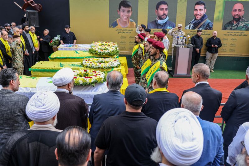 Hezbollah fighters and mourners attend a funeral of people killed after hundreds of paging devices exploded in a deadly wave across Lebanon the previous day, in a south Beirut district, on September 18, 2024. Hundreds of pagers used by Hezbollah members exploded across Lebanon on September 17, killing at least nine people and wounding around 2,800 in blasts the Iran-backed militant group blamed on Israel. (Photo by ANWAR AMRO / AFP) (Photo by ANWAR AMRO/AFP via Getty Images)