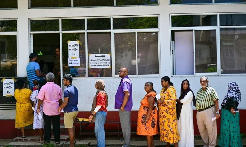 People wait in a queue to cast their ballots at a polling station during voting in Sri Lanka's presidential election in Colombo on September 21, 2024. Cash-strapped Sri Lanka began voting for its next president September 21 in an effective referendum on an unpopular International Monetary Fund austerity plan enacted after the island nation's unprecedented financial crisis. (Photo by Ishara S.KODIKARA / AFP) (Photo by ISHARA S.KODIKARA/AFP via Getty Images)