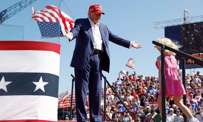 WILMINGTON, NORTH CAROLINA - SEPTEMBER 21: Republican presidential candidate former U.S. President Donald Trump greets his granddaughter Carolina onstage at a campaign rally at the Aero Center Wilmington on September 21, 2024 in Wilmington, North Carolina. Trump is returning to Wilmington, North Carolina after his previous scheduled rally in April was canceled because of a thunderstorm. (Photo by Anna Moneymaker/Getty Images)