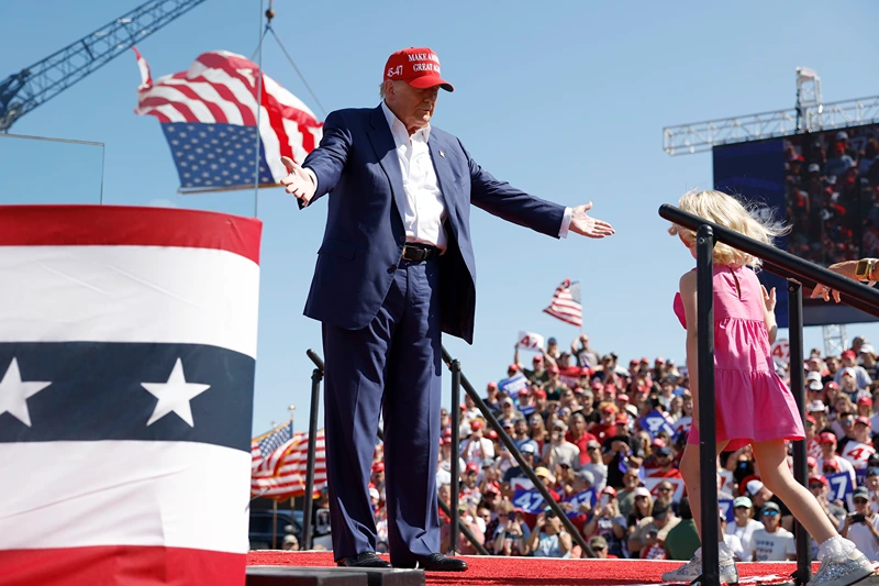 WILMINGTON, NORTH CAROLINA - SEPTEMBER 21: Republican presidential candidate former U.S. President Donald Trump greets his granddaughter Carolina onstage at a campaign rally at the Aero Center Wilmington on September 21, 2024 in Wilmington, North Carolina. Trump is returning to Wilmington, North Carolina after his previous scheduled rally in April was canceled because of a thunderstorm. (Photo by Anna Moneymaker/Getty Images)
