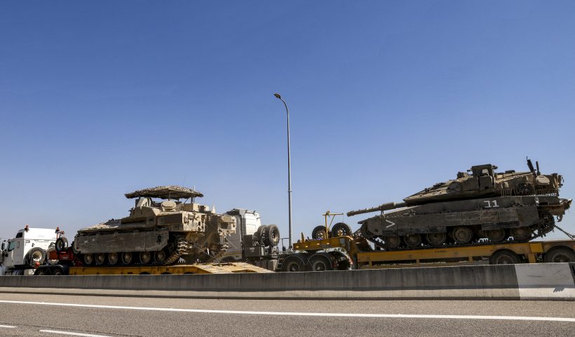 Trucks transport an Israeli army main battle tank and an infantry-fighting vehicle (IFV) headed for deployment along the border with Lebanon, along a highway in northern Israel on September 28, 2024. (Photo by Jalaa MAREY / AFP) (Photo by JALAA MAREY/AFP via Getty Images)