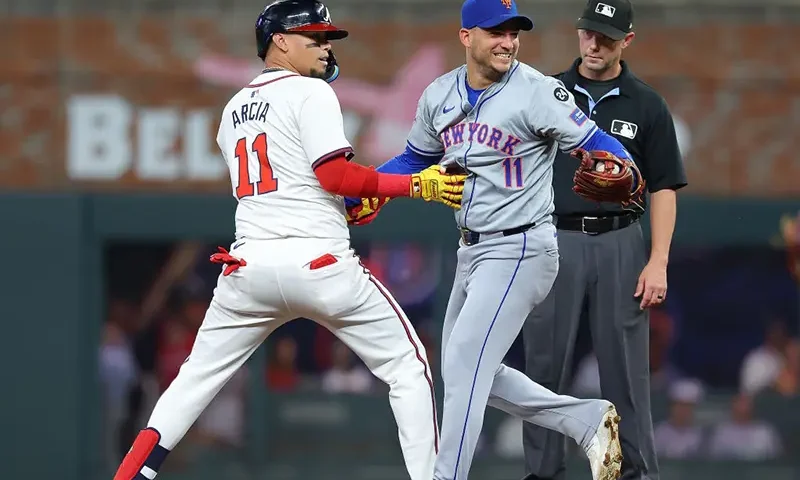 Orlando Arcia #11 of the Atlanta Braves and Jose Iglesias #11 of the New York Mets horse around at second base after Arcia's single leading off the third inning at Truist Park on September 24, 2024 in Atlanta, Georgia. (Photo by Kevin C. Cox/Getty Images)