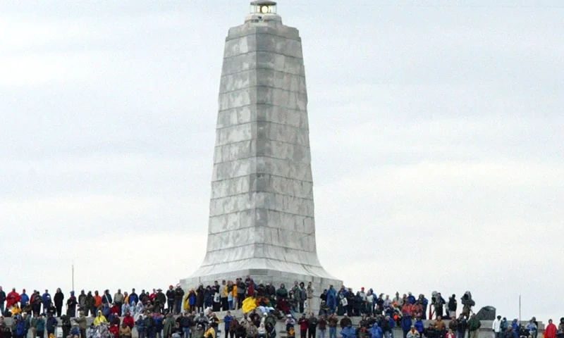 Spectators wait to see a second attempt at flying a replica of the 1903 Wright Flyer after an unsuccessful first attempt marking the Wright brother's historic first flight during Centennial celebrations at the Wright Brothers National Memorial December 17, 2003 in Kill Devil Hills, North Carolina. The reenactment marked the finale of the six-day celebration. (Photo by Corey Lowenstein-Pool/Getty Images)