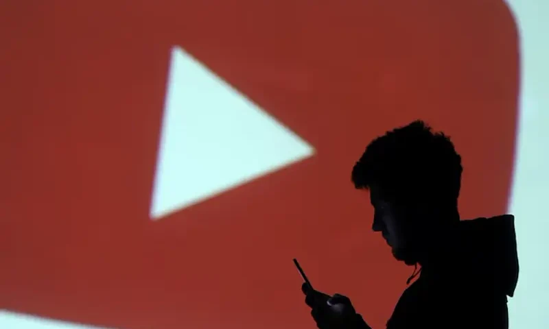 A silhouette of a mobile user is seen next to a screen projection of Youtube logo in this picture illustration taken March 28, 2018. REUTERS/Dado Ruvic/Illustration/ File Photo