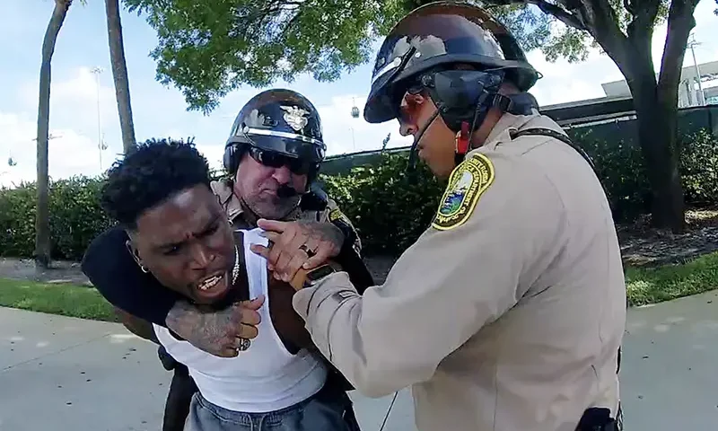 Miami Dolphins receiver Tyreek Hill is forced to the ground after being handcuffed and led to the sidewalk by Miami-Dade Police Department officers in Miami, Florida, September 8, 2024 in a still image from police body camera video. Miami-Dade Police Department/Handout via REUTERS