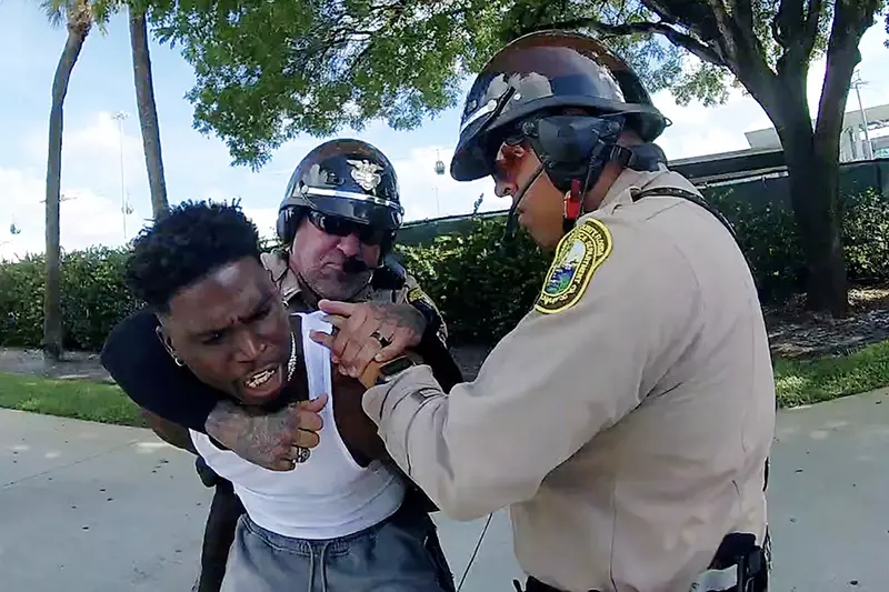 Miami Dolphins receiver Tyreek Hill is forced to the ground after being handcuffed and led to the sidewalk by Miami-Dade Police Department officers in Miami, Florida, September 8, 2024 in a still image from police body camera video. Miami-Dade Police Department/Handout via REUTERS